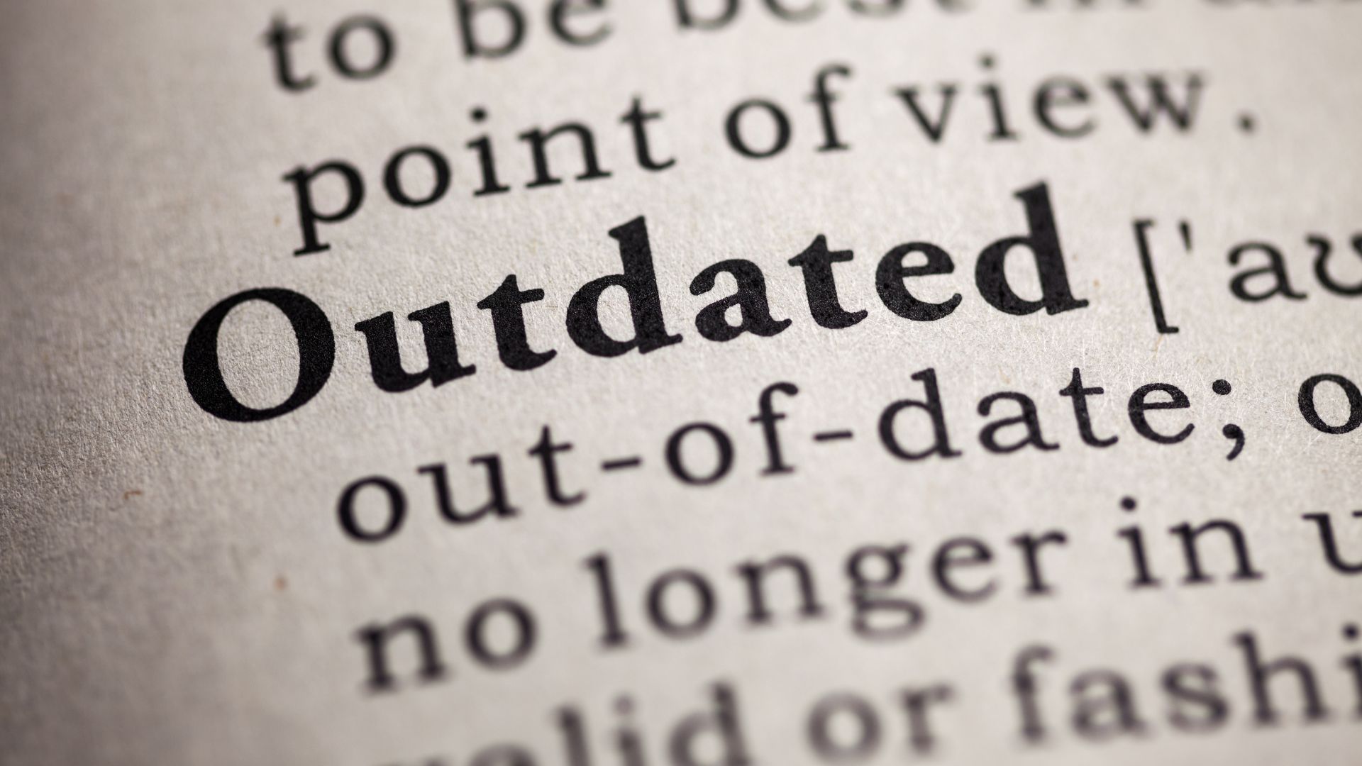 Close-up of a dictionary page highlighting the word “Outdated” with its definition.